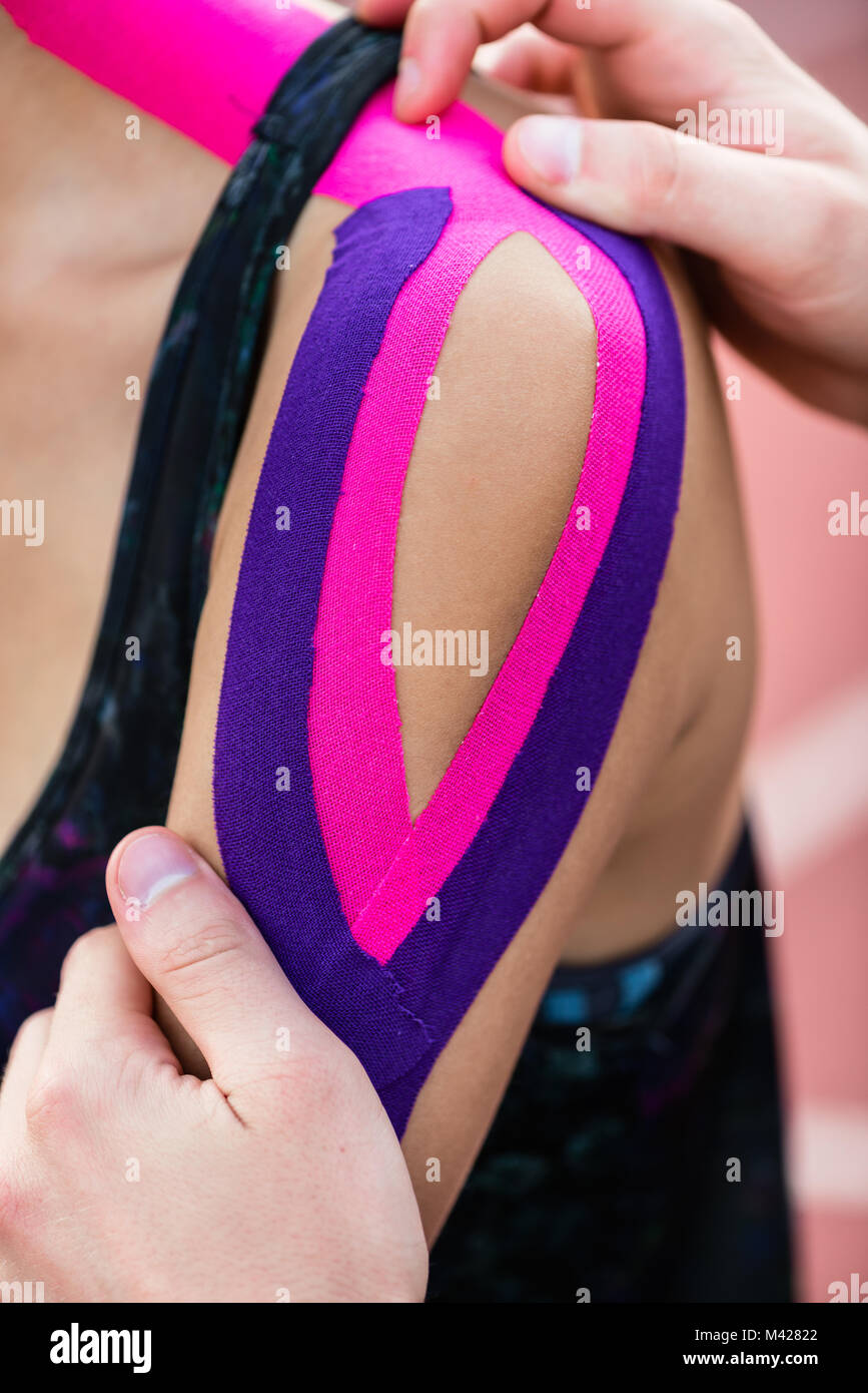 Woman taping with therapeutic tape on cinder track of sports sta Stock Photo