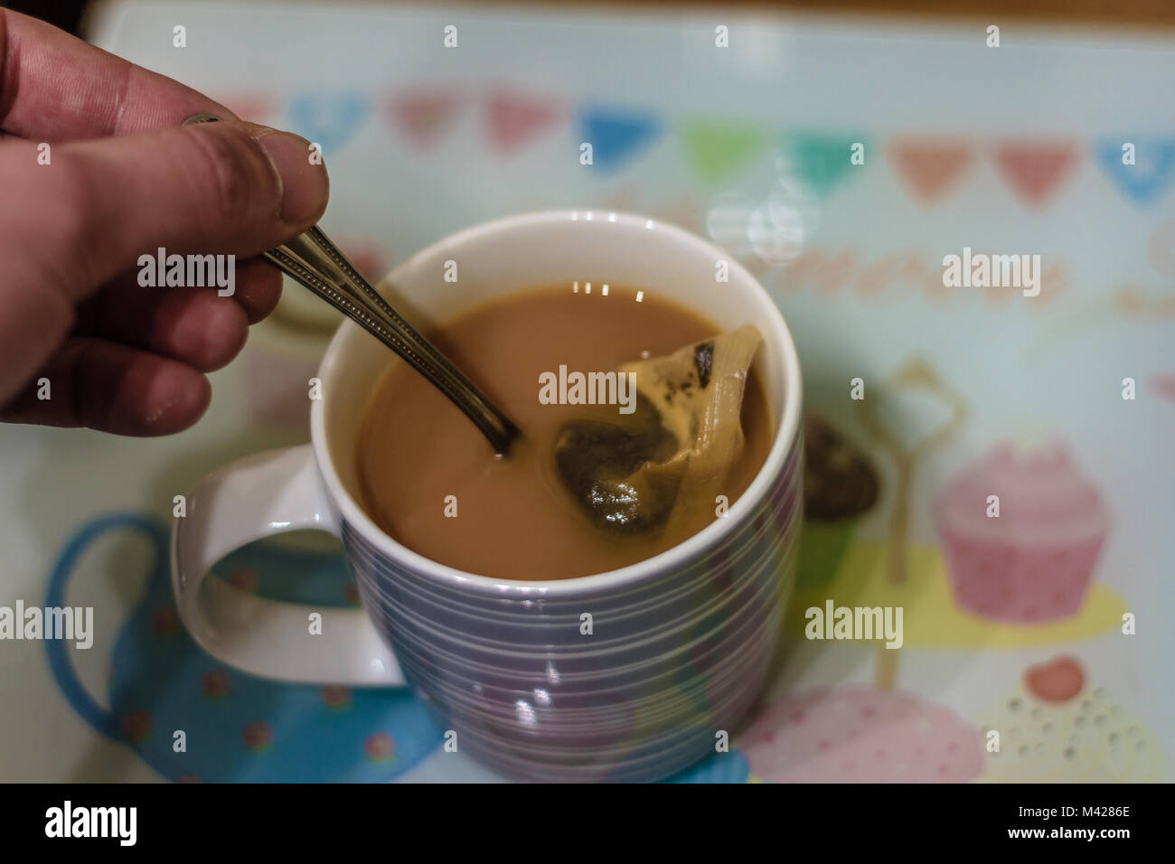 Mug of tea made with a teabag being stirred with a teaspoon. Stock Photo