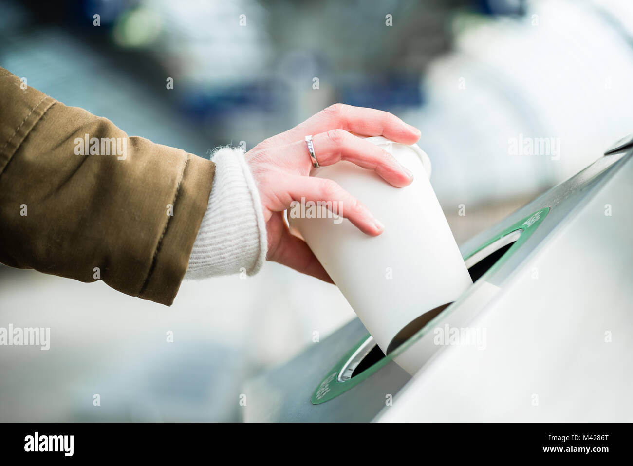 Woman using waste separation container throwing away coffee cup Stock