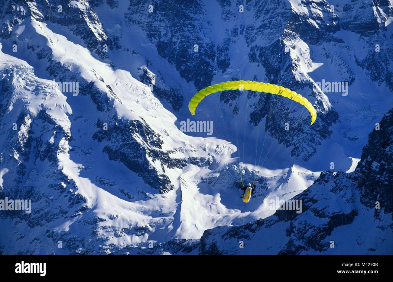 Switzerland. Murren. Berner Oberland. Jungfrau region. Person Paragliding by Mountain. Stock Photo