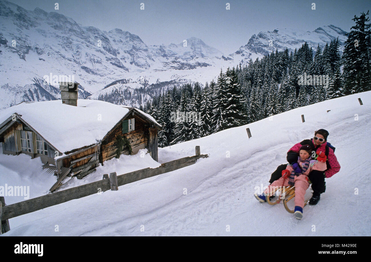 Switzerland. Murren. Berner Oberland. Jungfrau region. Mother and daughter sledging. Stock Photo