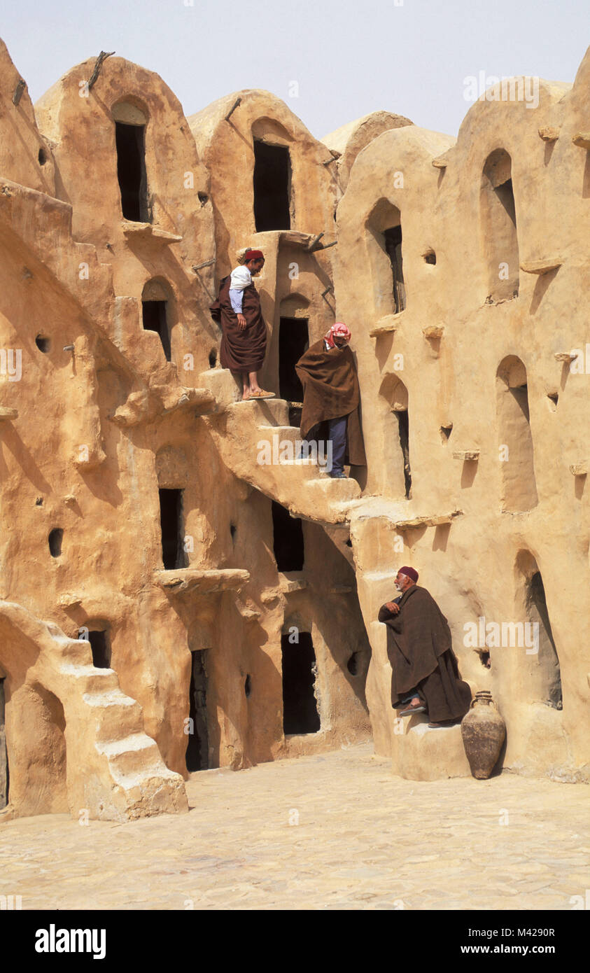 Tunisia. Ouled Soltane near Tatahouine oasis. Sahara desert. Granery. Berber tribe. Three Berber Men Walking Down Stairs. Stock Photo