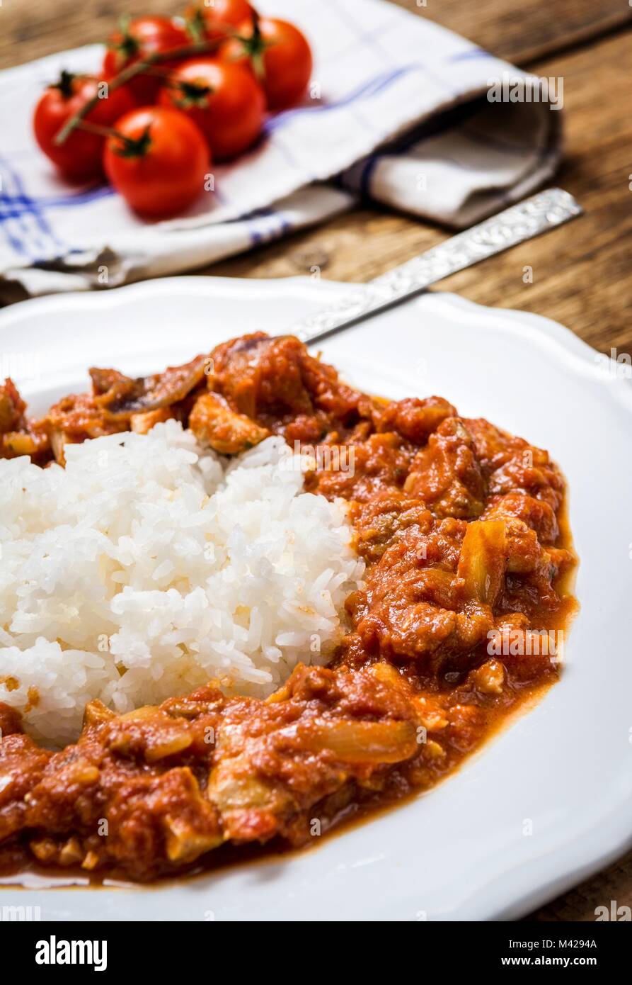 Traditional indian cuisine. Spicy tikka masala with rice on wood table Stock Photo