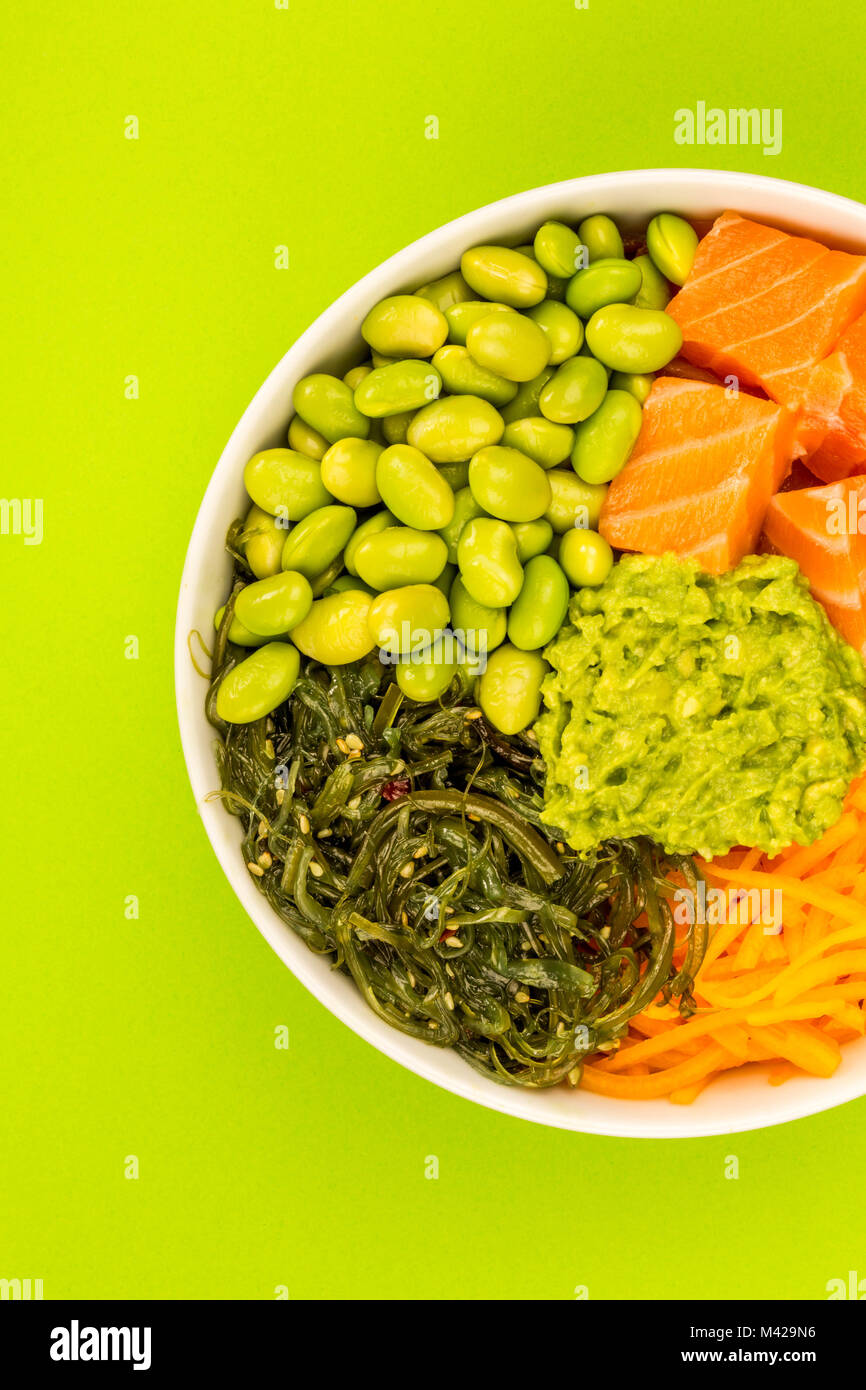 Hawaiian Style Raw Salmon Sashimi Poke Bowl With Edamame Beans And Seaweed Against A Green
