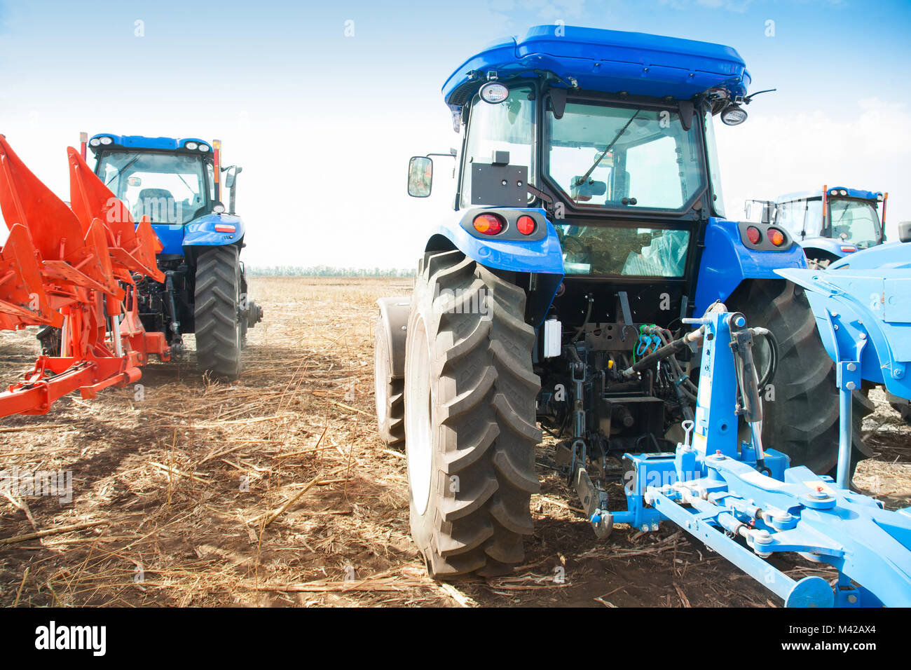 Two blue tractors in the empty field. Agricultural machinery Stock