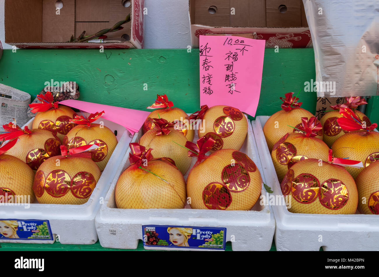 Pomelos stick with good luck stickers in San Francisco Chinatown market
