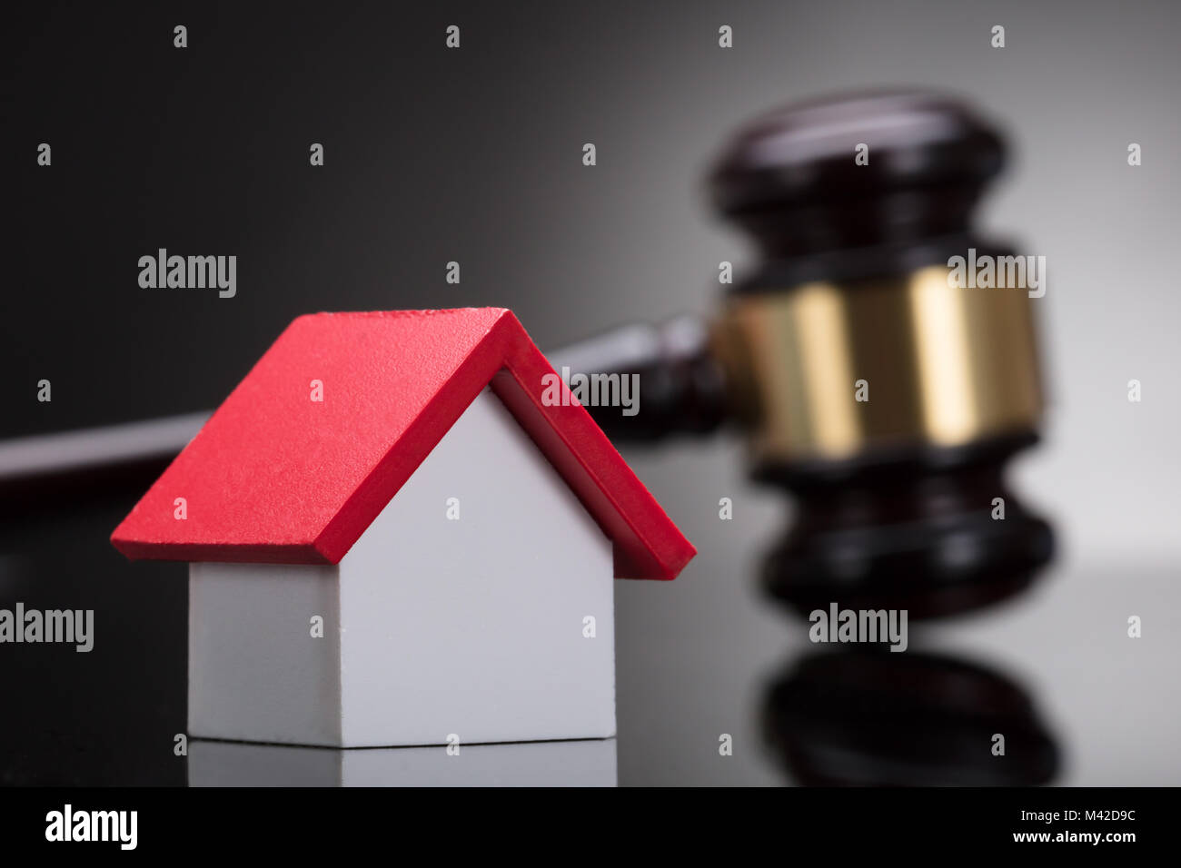 Close-up Of A House Model In Front Of Gavel Stock Photo