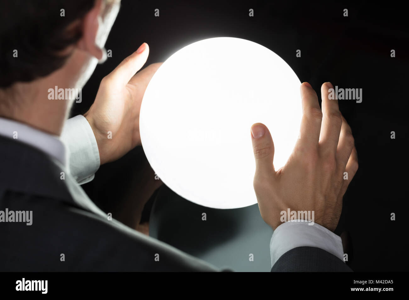 Close-up Of A Businessman's Hand Predicting Future With Glowing Crystal Ball Stock Photo