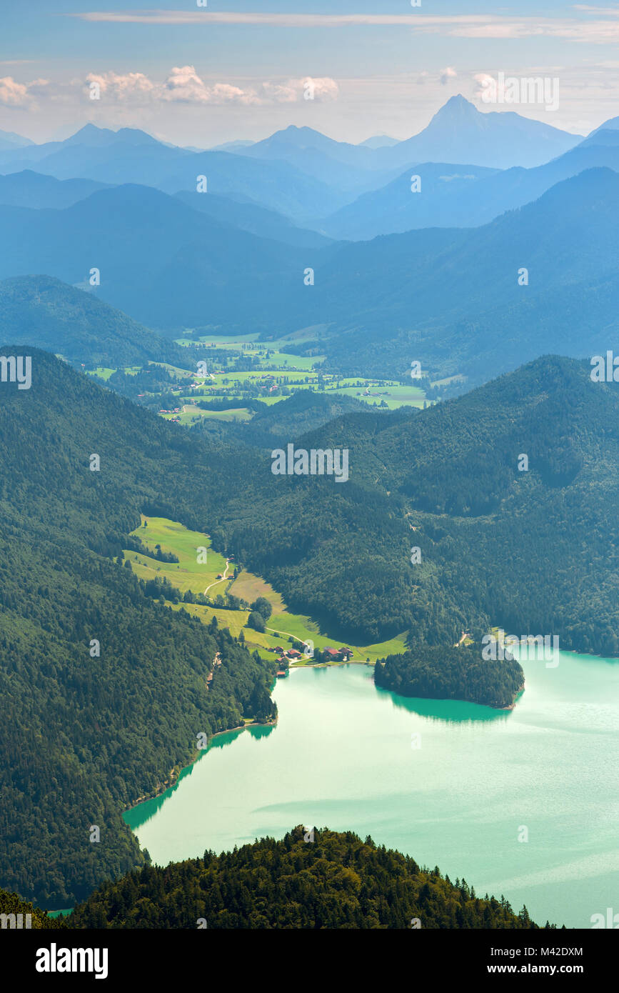 Walchensee lake and green valley against distant mountains Stock Photo