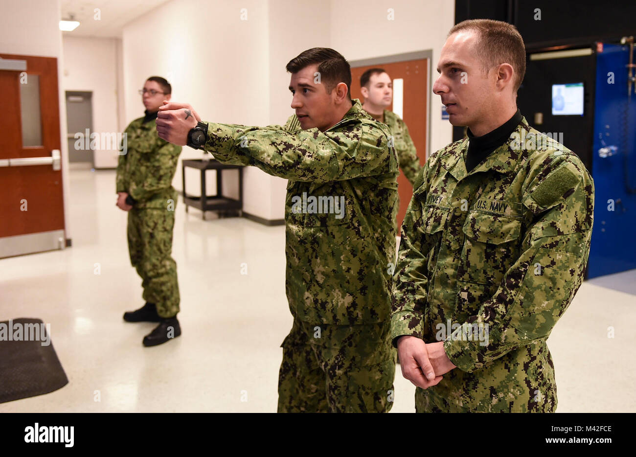 GREAT LAKES, Ill (Feb. 5, 2018) Gunner’s Mate 1st Class David Tercero instructs a recruit before he shoots at USS Missouri Simulated Arms Marksmanship Trainer (SAMT). USS Missouri is where recruits first become familiarized with firing a weapon with simulated laser-guided, air-compressed, 9-millimeter handguns and 12-gauge shotguns. About 30,000 to 40,000 recruits graduate annually from the Navy's only boot camp. (U.S. Navy Stock Photo