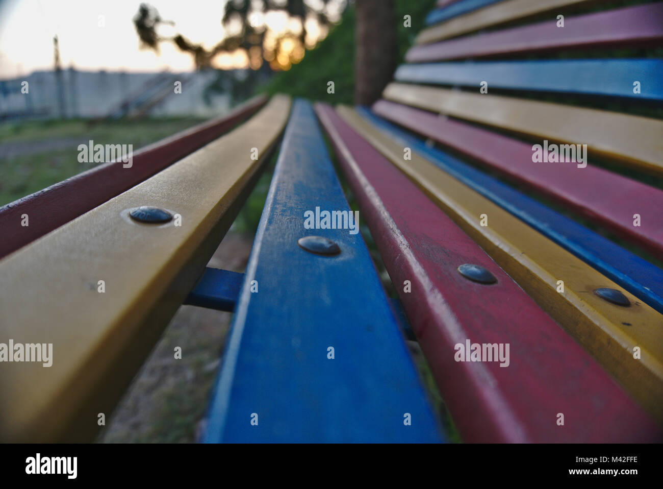 An empty colorful park bench at a playground. Stock Photo