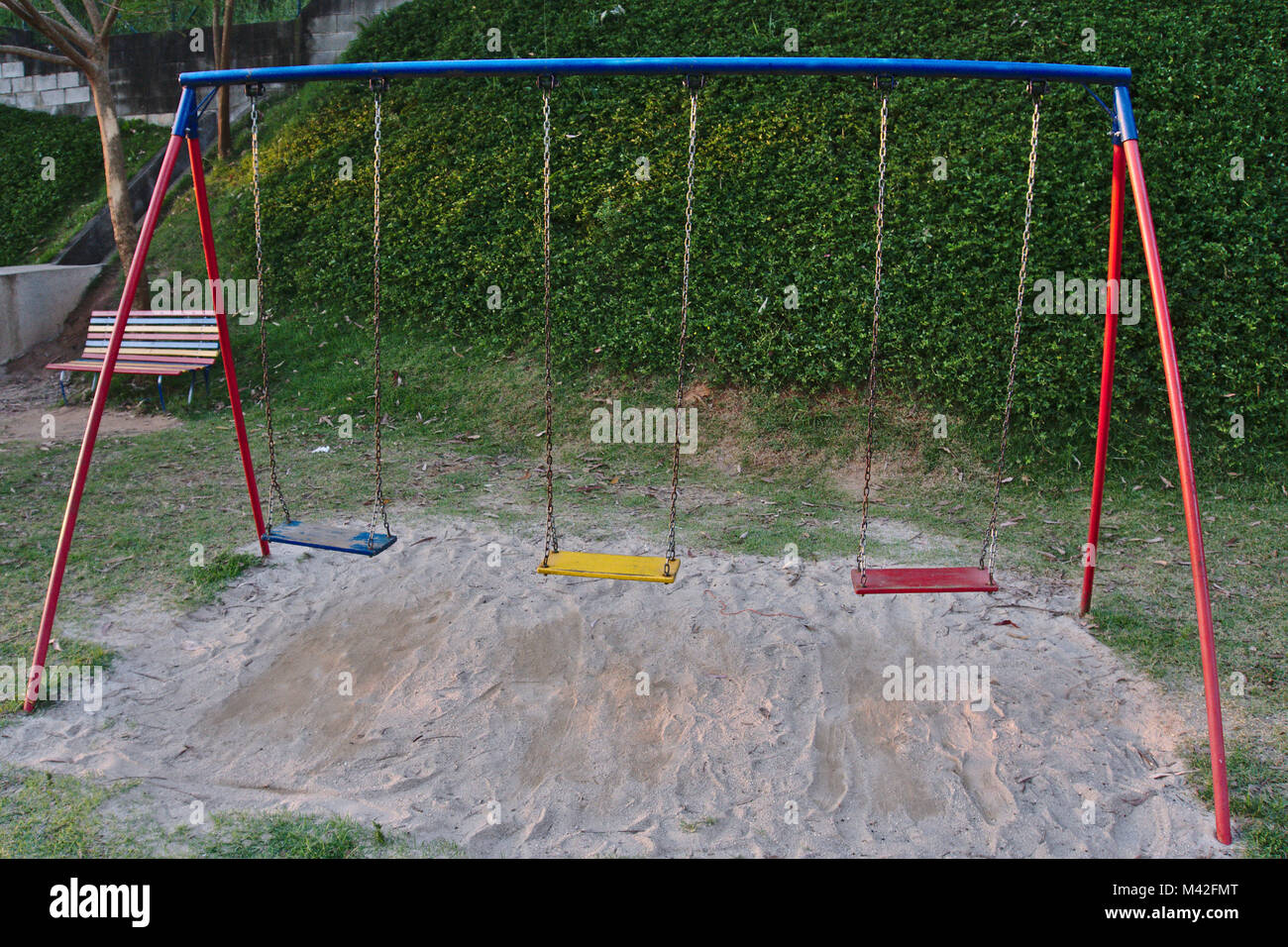 Three empty colorful swings at a playground. Stock Photo
