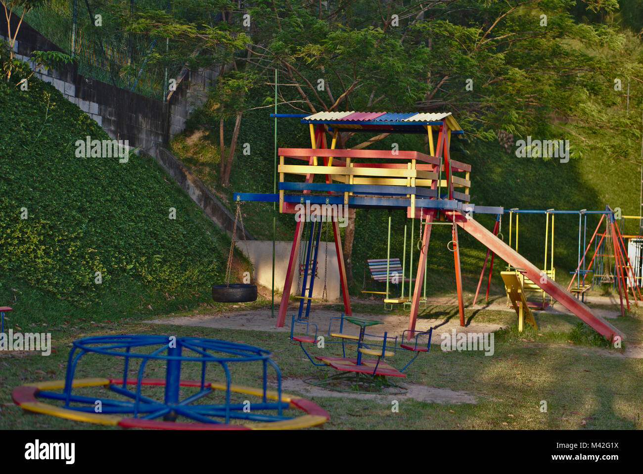 Colorful playground wood house and a colorful roundabout at a playground. Stock Photo