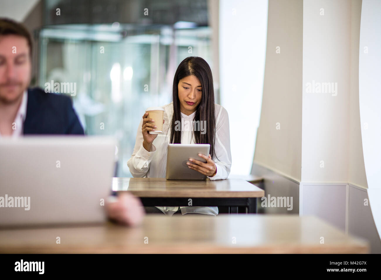 Businesswoman in a café reading a digital tablet Stock Photo