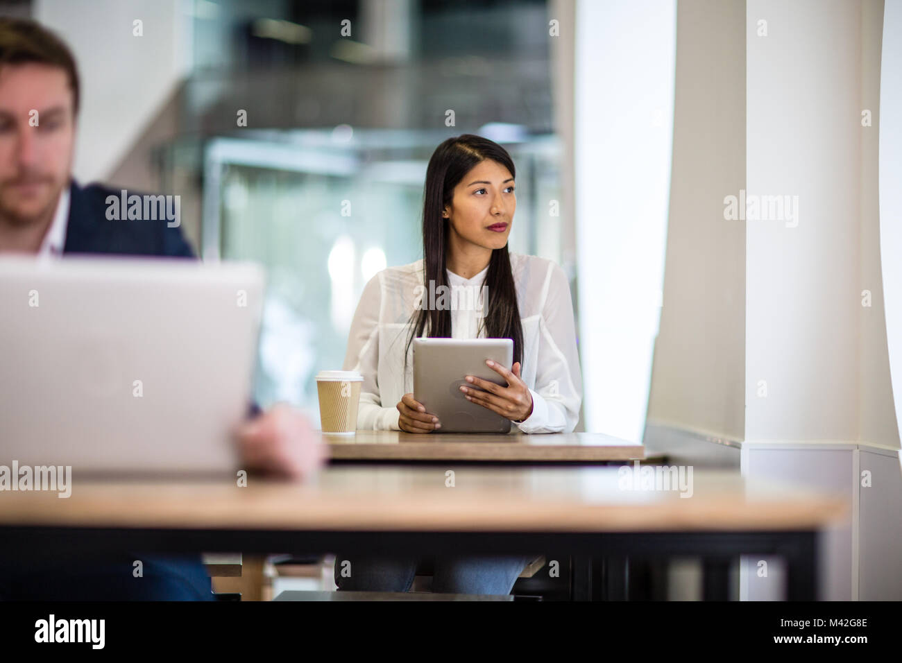 Businesswoman in a café looking out of window Stock Photo