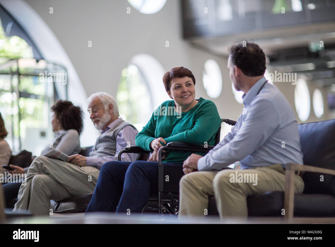 Disabled woman talking with Doctor in waiting room Stock Photo