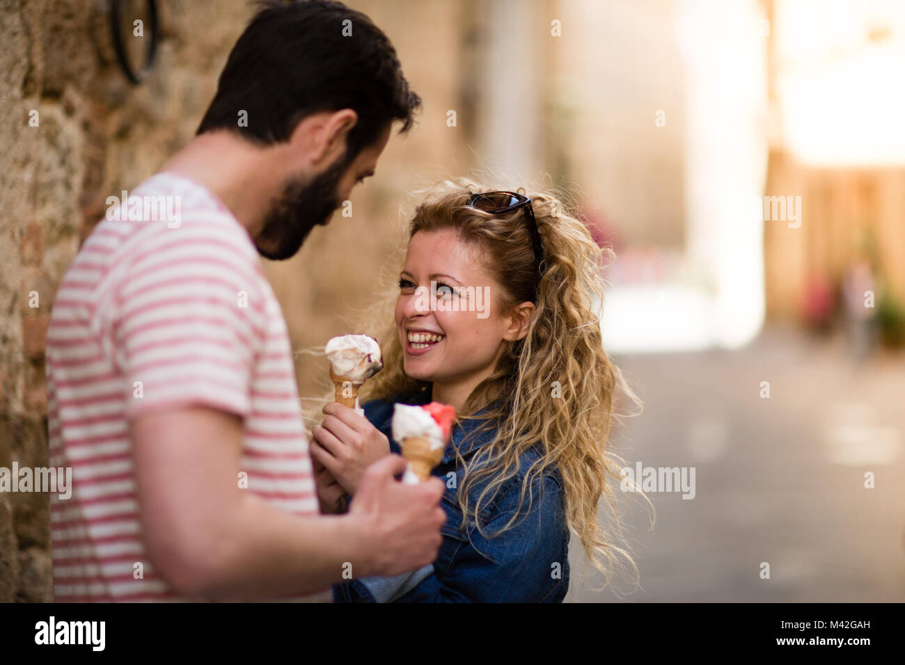 Young female eating gelato with boyfriend Stock Photo