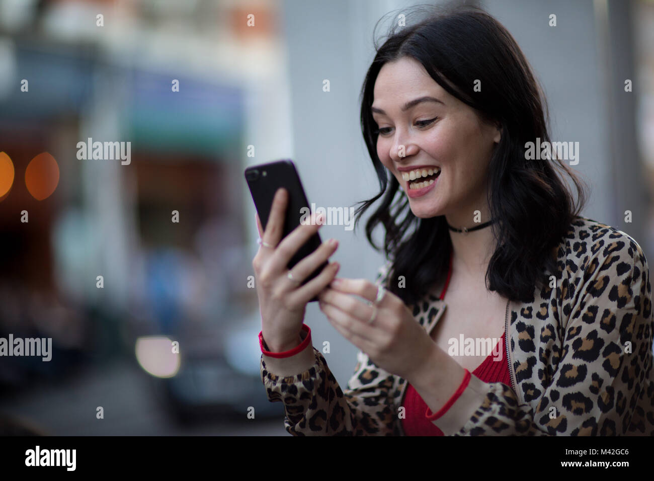 Young adult female on a video call with friend outdoors Stock Photo
