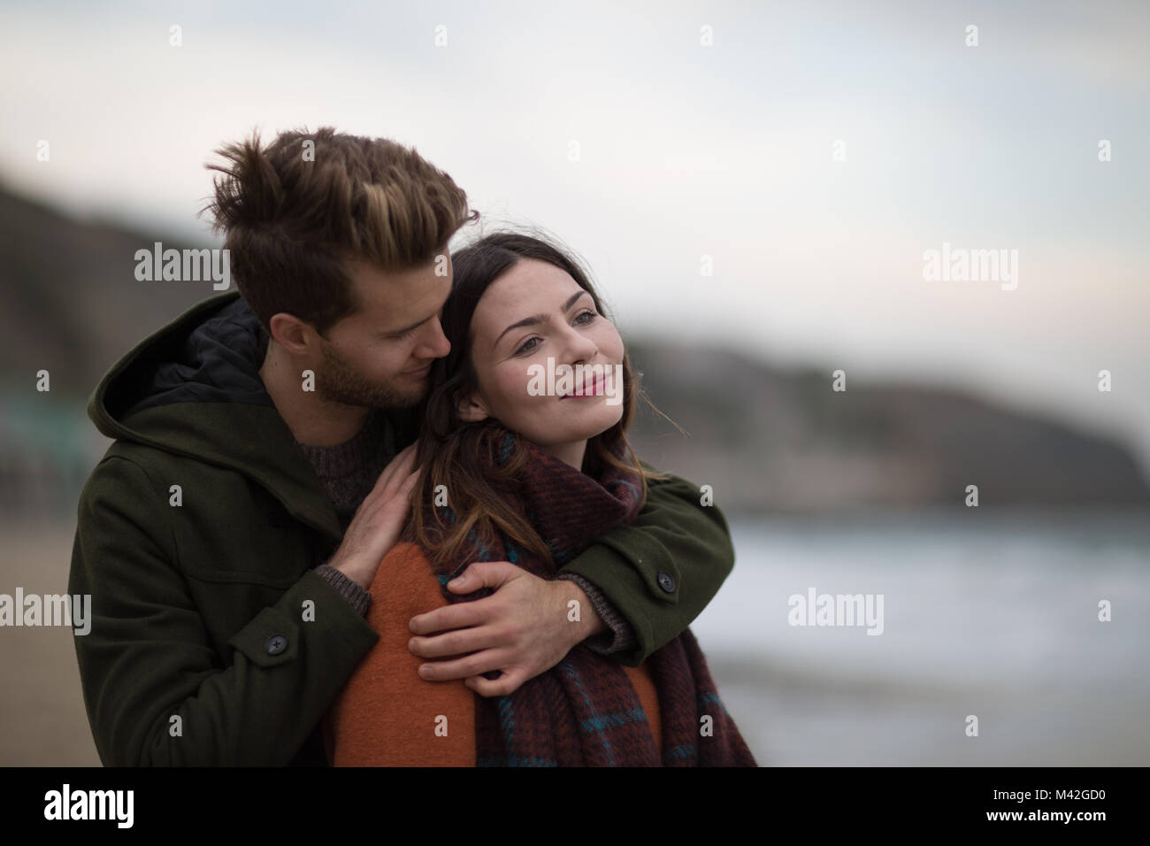 Young adult couple hugging on beach Stock Photo