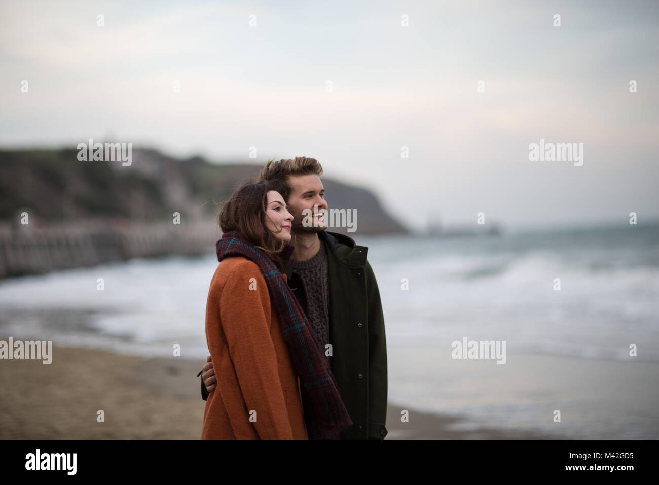Young adult couple walking on beach Stock Photo