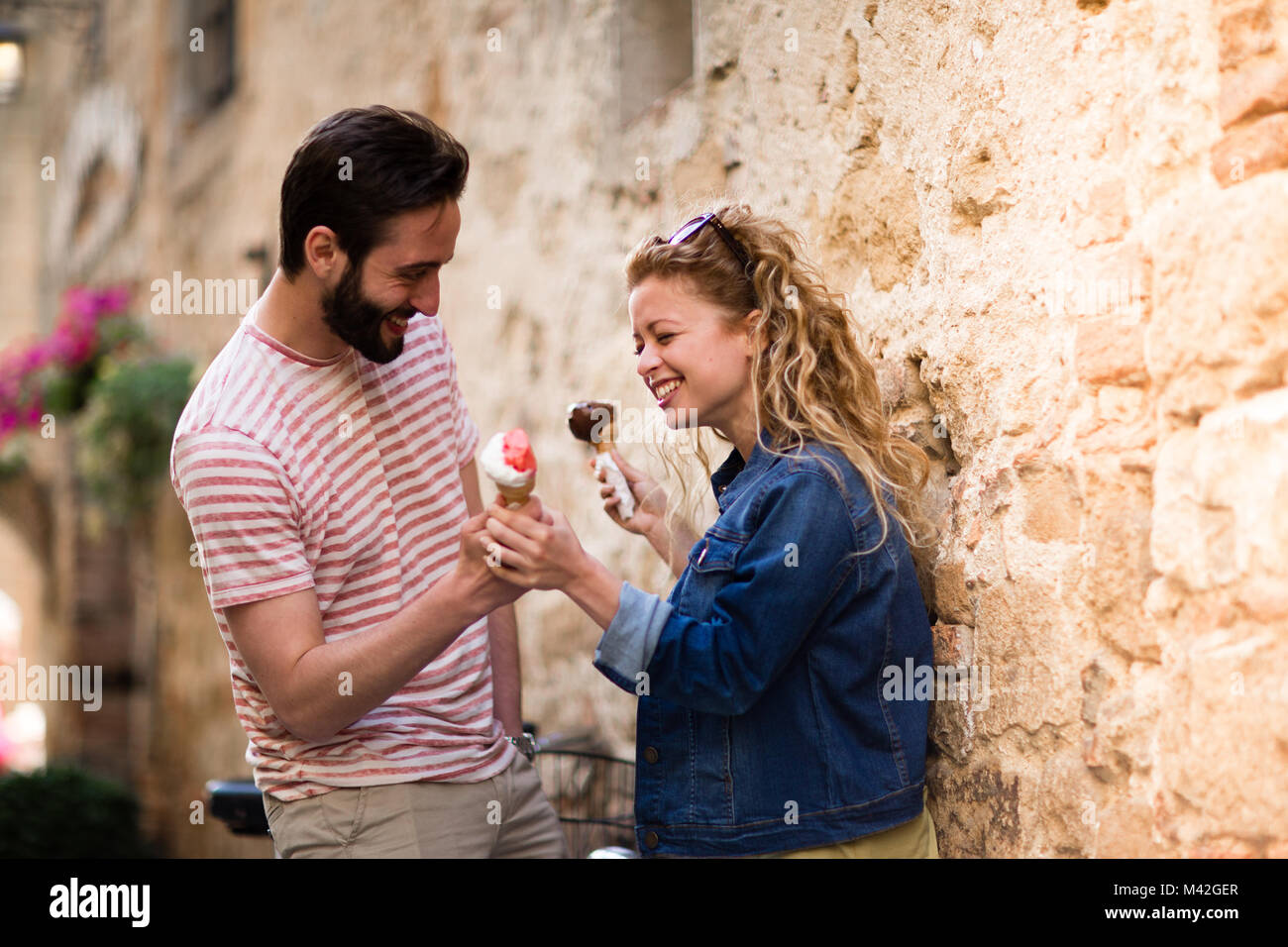 Young female eating gelato with boyfriend Stock Photo