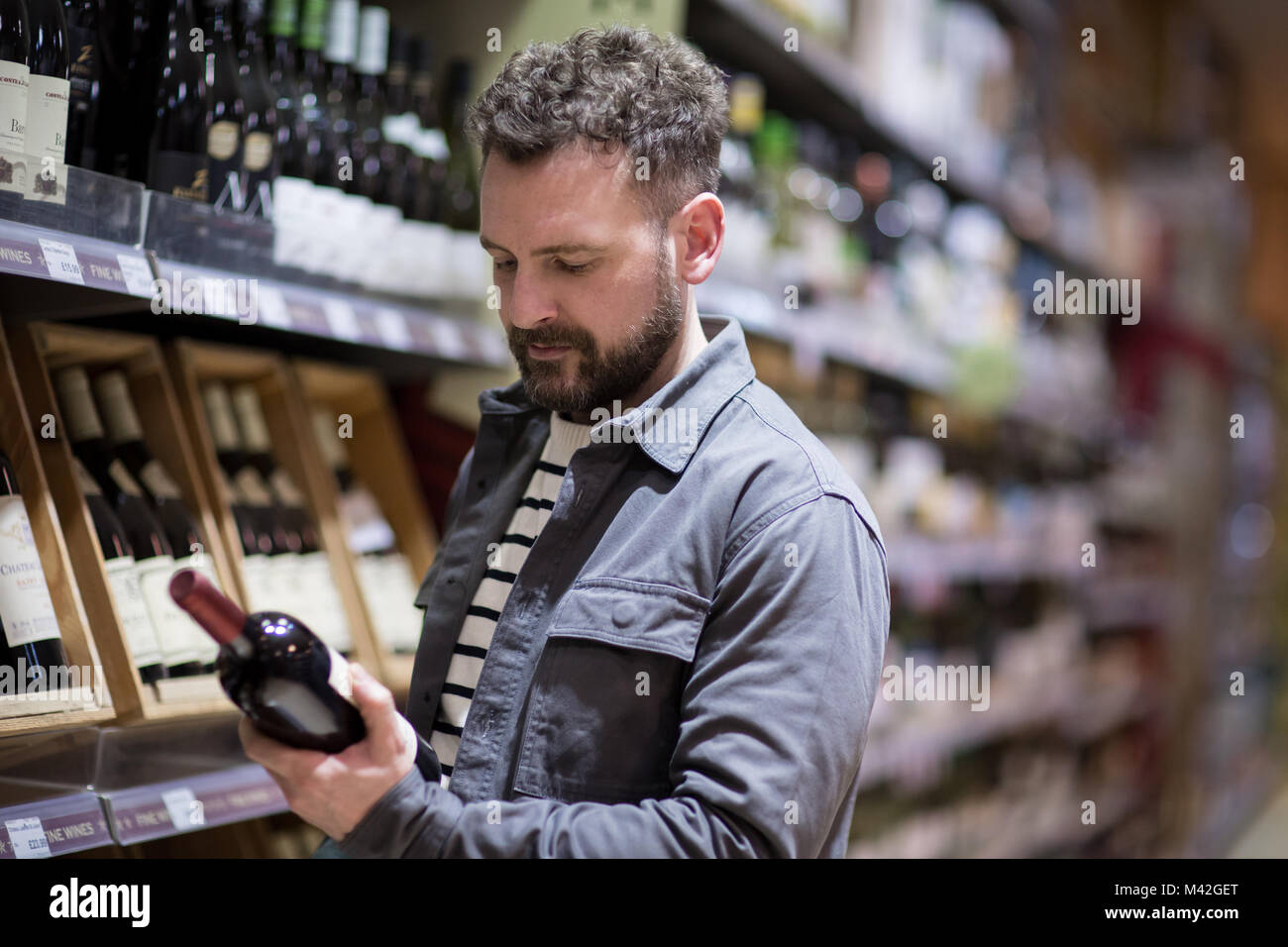 Man choosing wine in grocery store Stock Photo