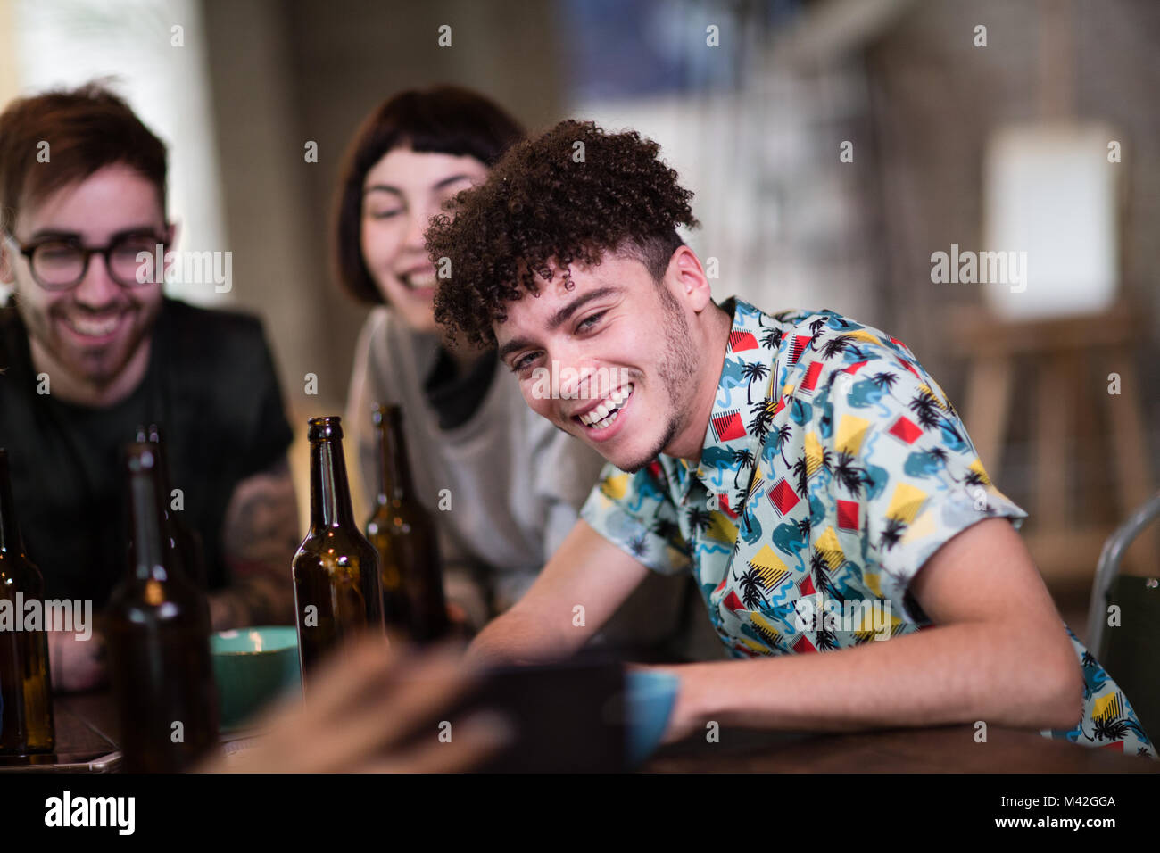 Group of friends looking at a smartphone together in a pub Stock Photo