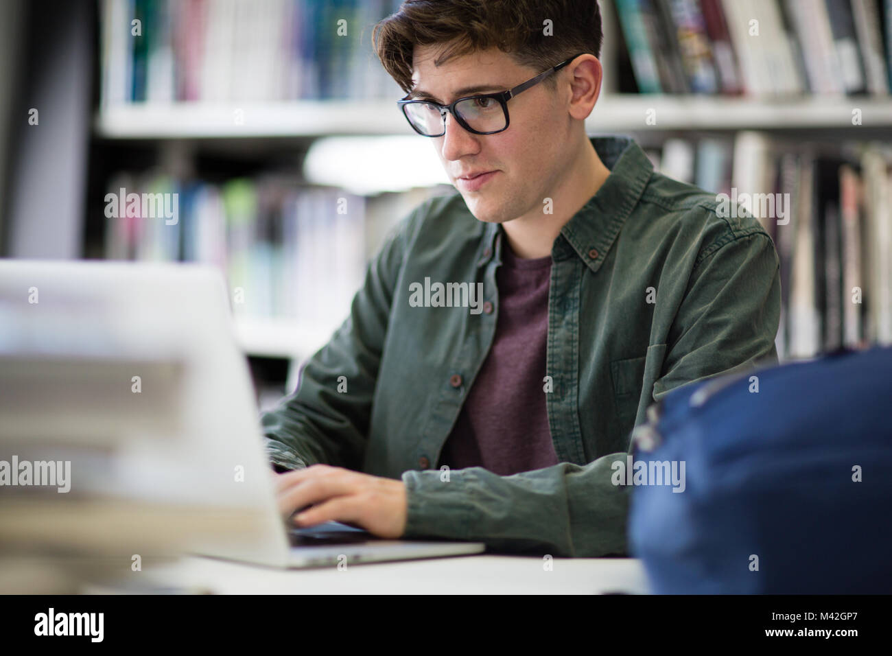 Student working on laptop in library Stock Photo