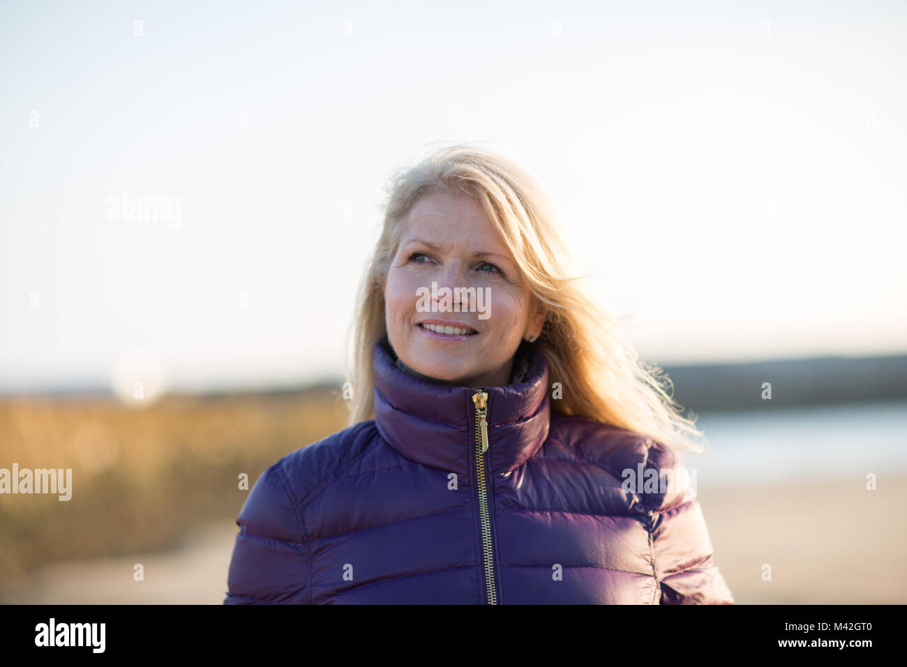 Mature female enjoying the outdoors in winter on the beach Stock Photo