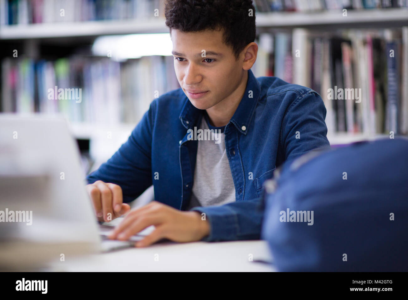 Student working on laptop in library Stock Photo