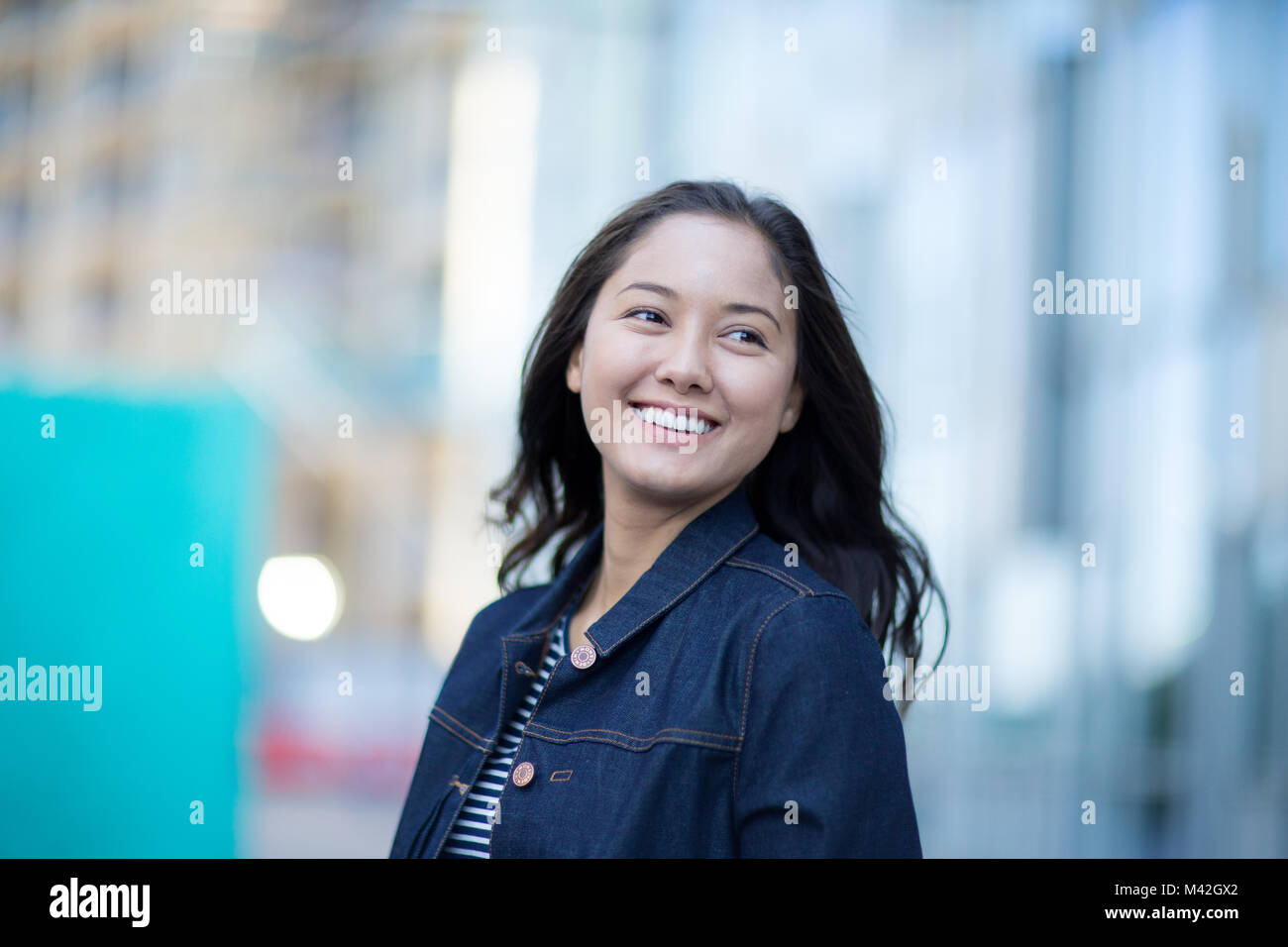 Young adult walking down street in a city Stock Photo