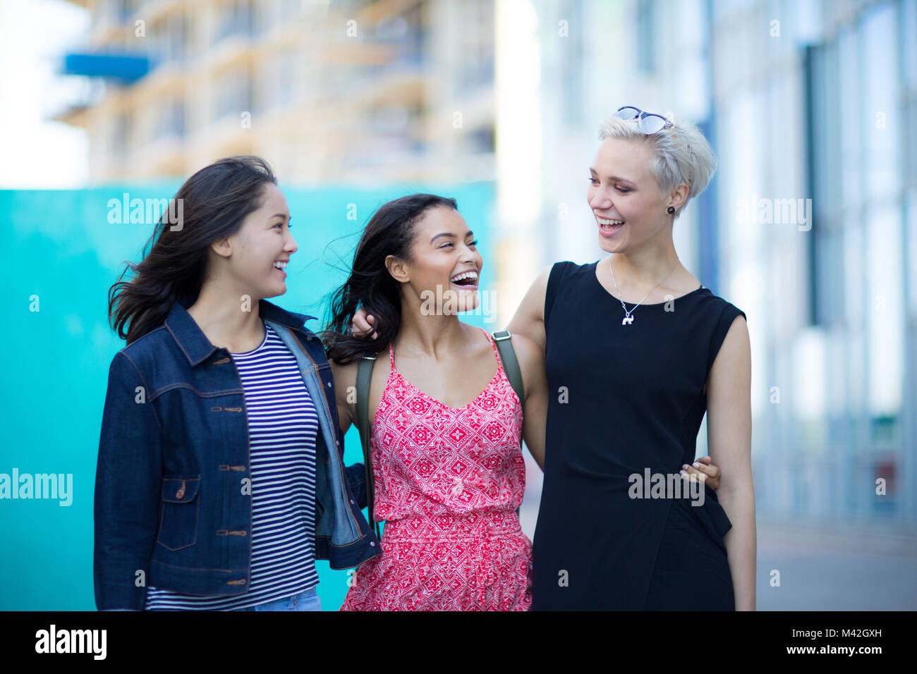 Young adults walking down a street together Stock Photo