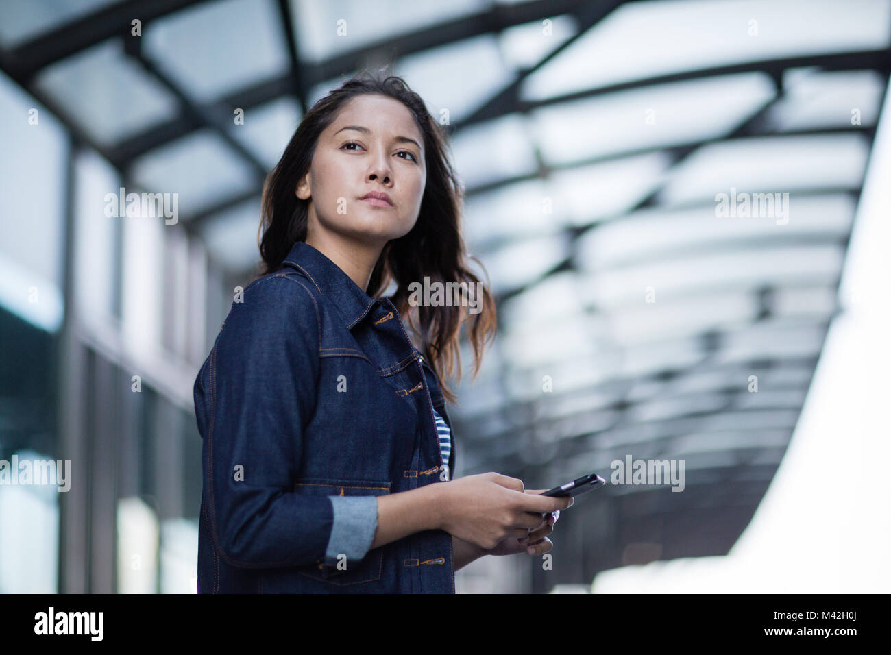 Young adult waiting on station platform Stock Photo