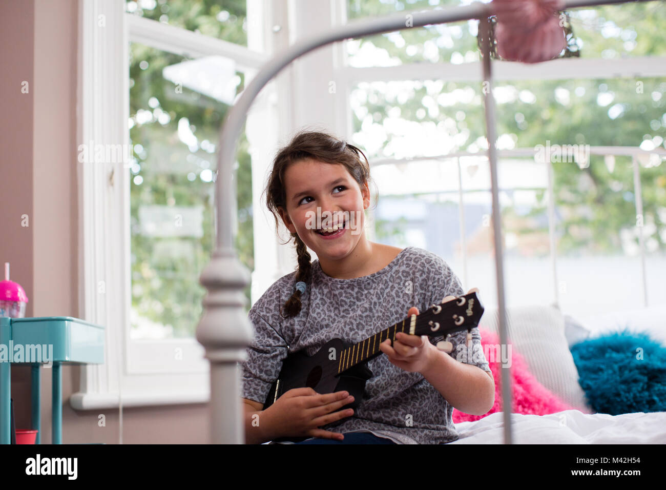 Girl playing a ukulele Stock Photo