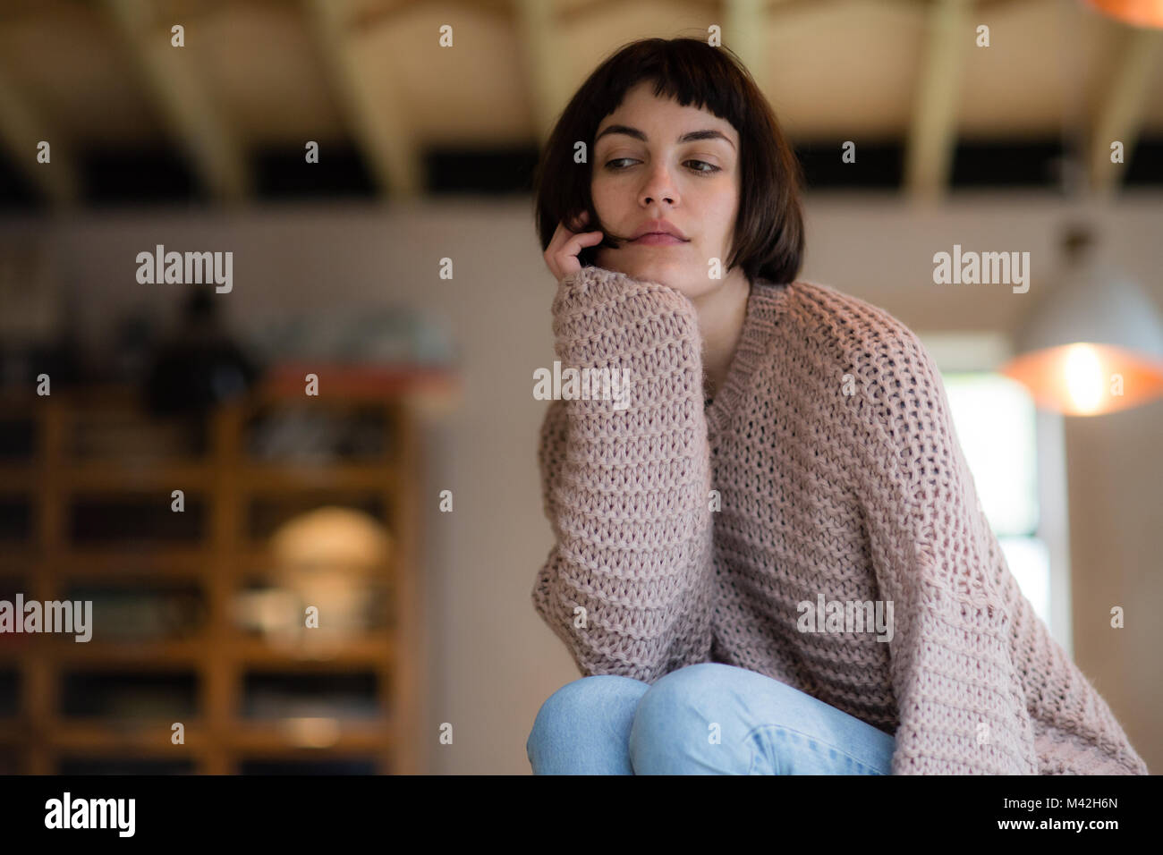 Young adult female looking thoughtful at home Stock Photo