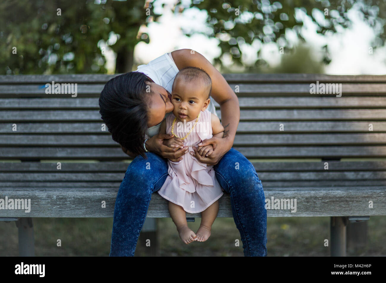 Mum kissing baby girl Stock Photo