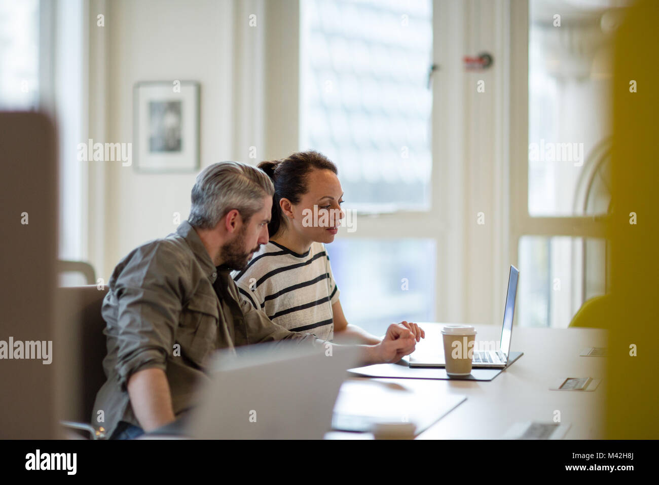 Coworkers looking at a laptop together Stock Photo