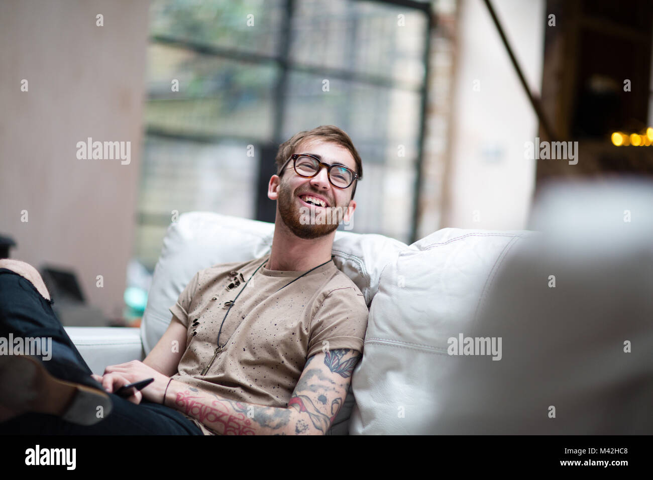 Young adult male laughing at home Stock Photo