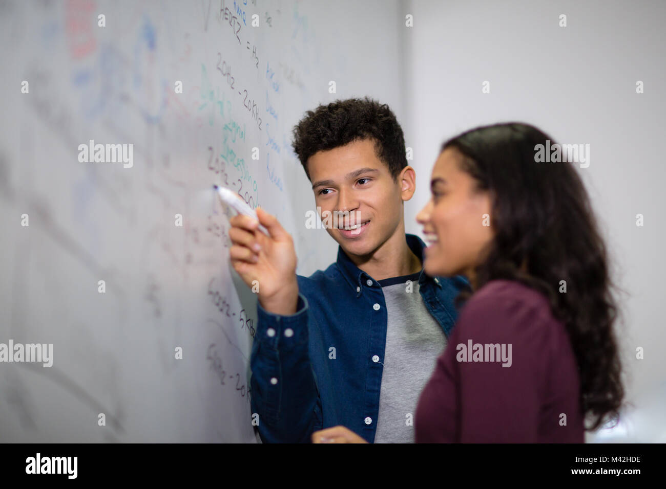 Students at a whiteboard with pen Stock Photo