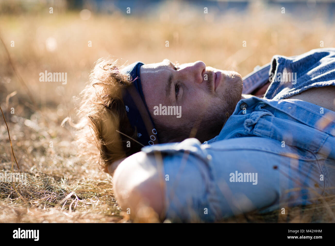 Young adult lying on grass in summer Stock Photo