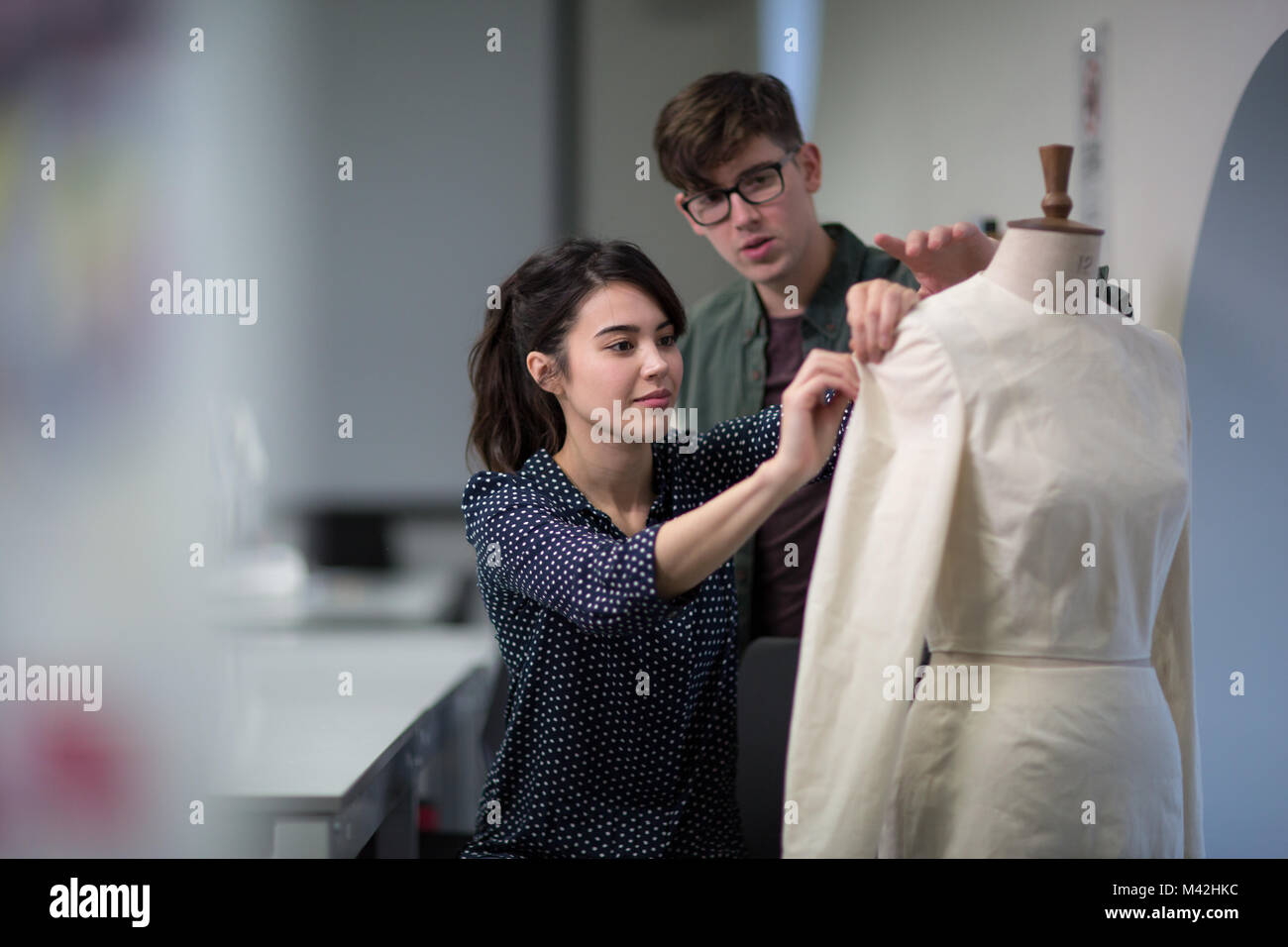 Fashion students working on a design together Stock Photo
