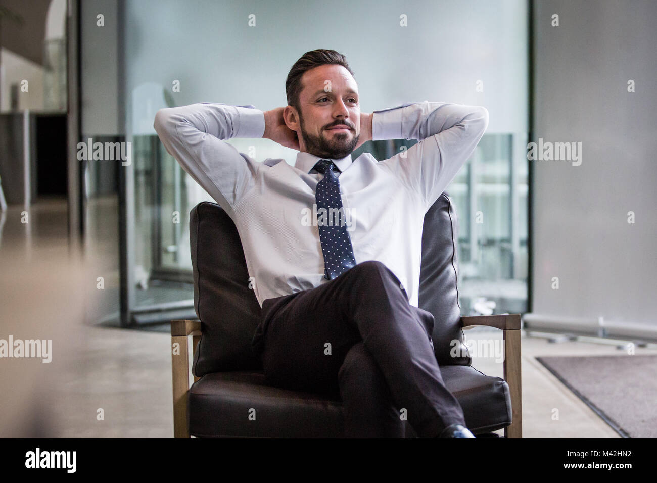 Successful businessman leaning back in chair Stock Photo