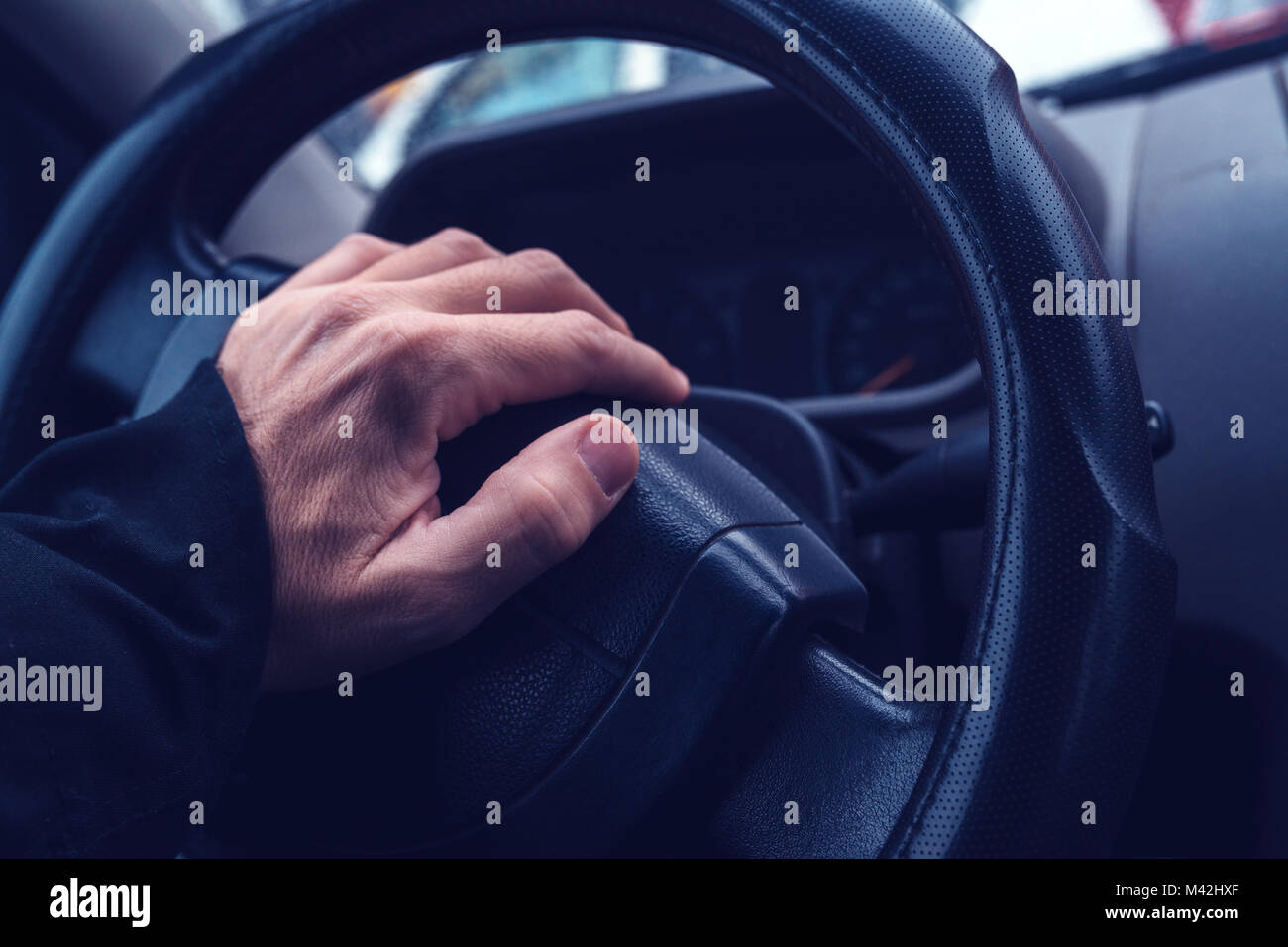 Male hand honking the car horn, man driving vehicle and beeping, ultra violey toned shadows