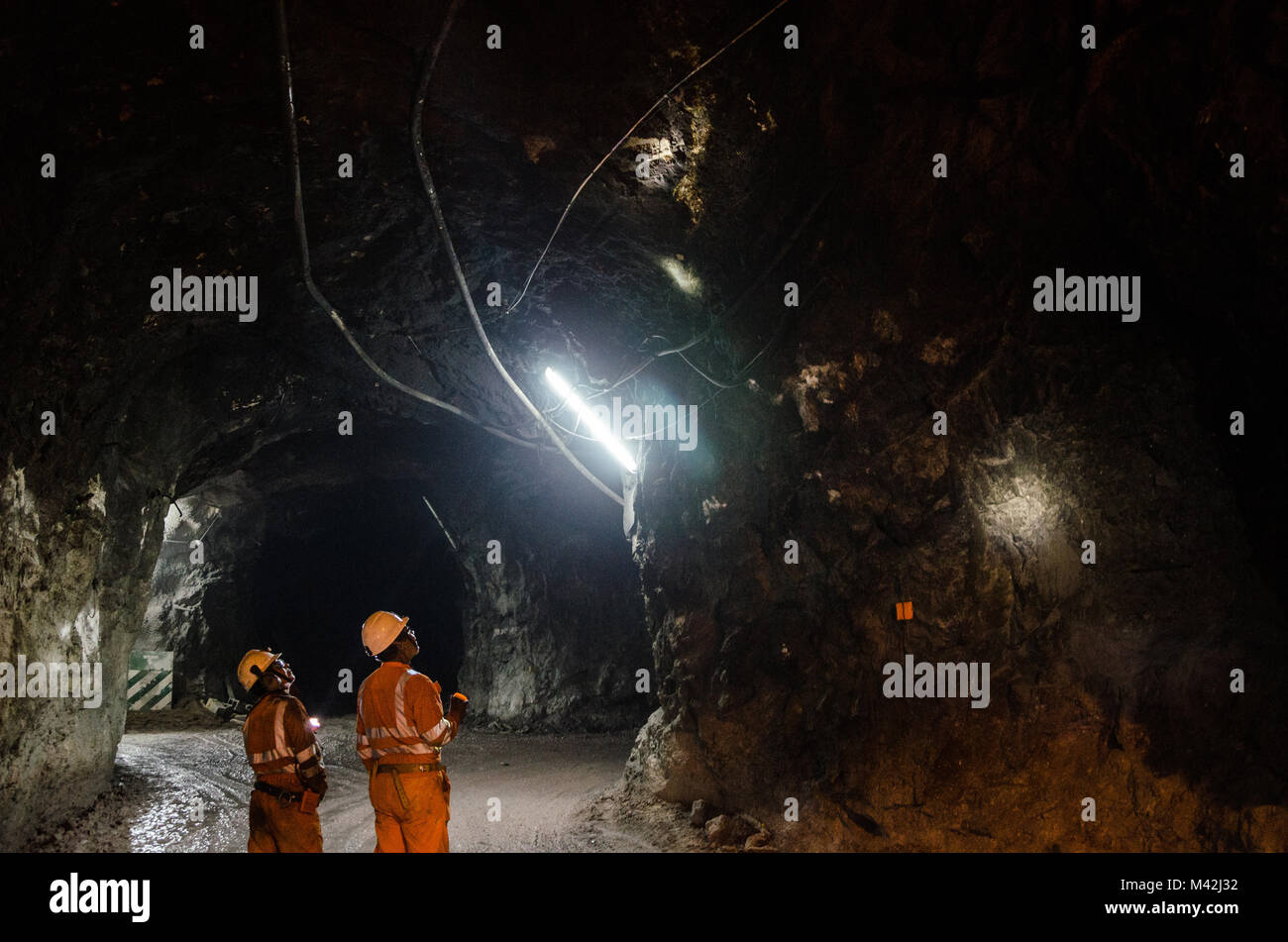 Two miners observing the cavern Stock Photo