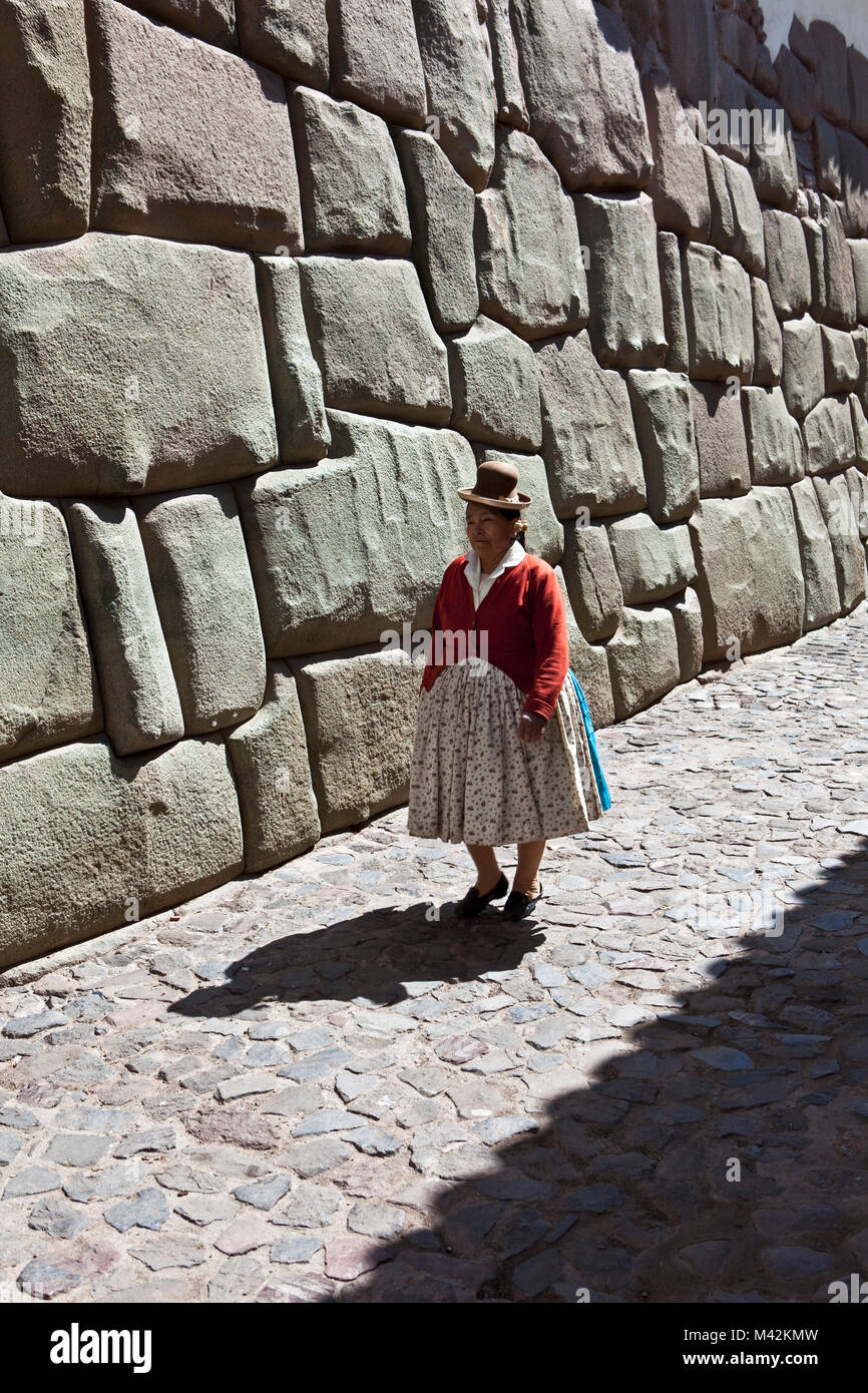 Peru, Cusco, Cuzco, Wall of the Museum of Religious Art. Examples of polygonal masonry. Indian woman.  Unesco World Heritage Site. Stock Photo