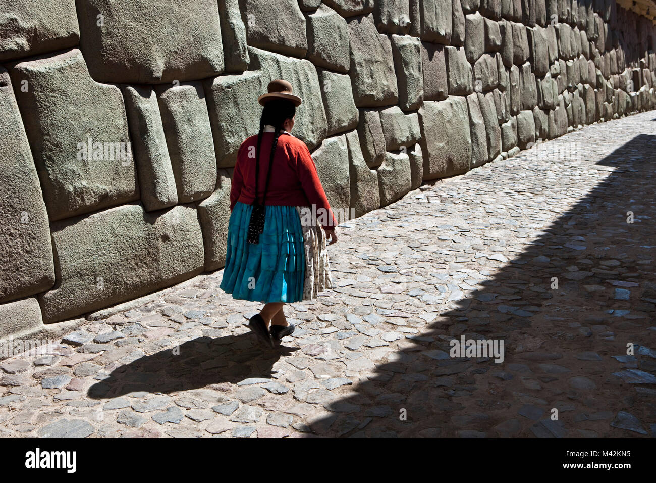 Peru, Cusco, Cuzco, Wall of the Museum of Religious Art. Examples of polygonal masonry. Indian woman.  Unesco World Heritage Site. Stock Photo