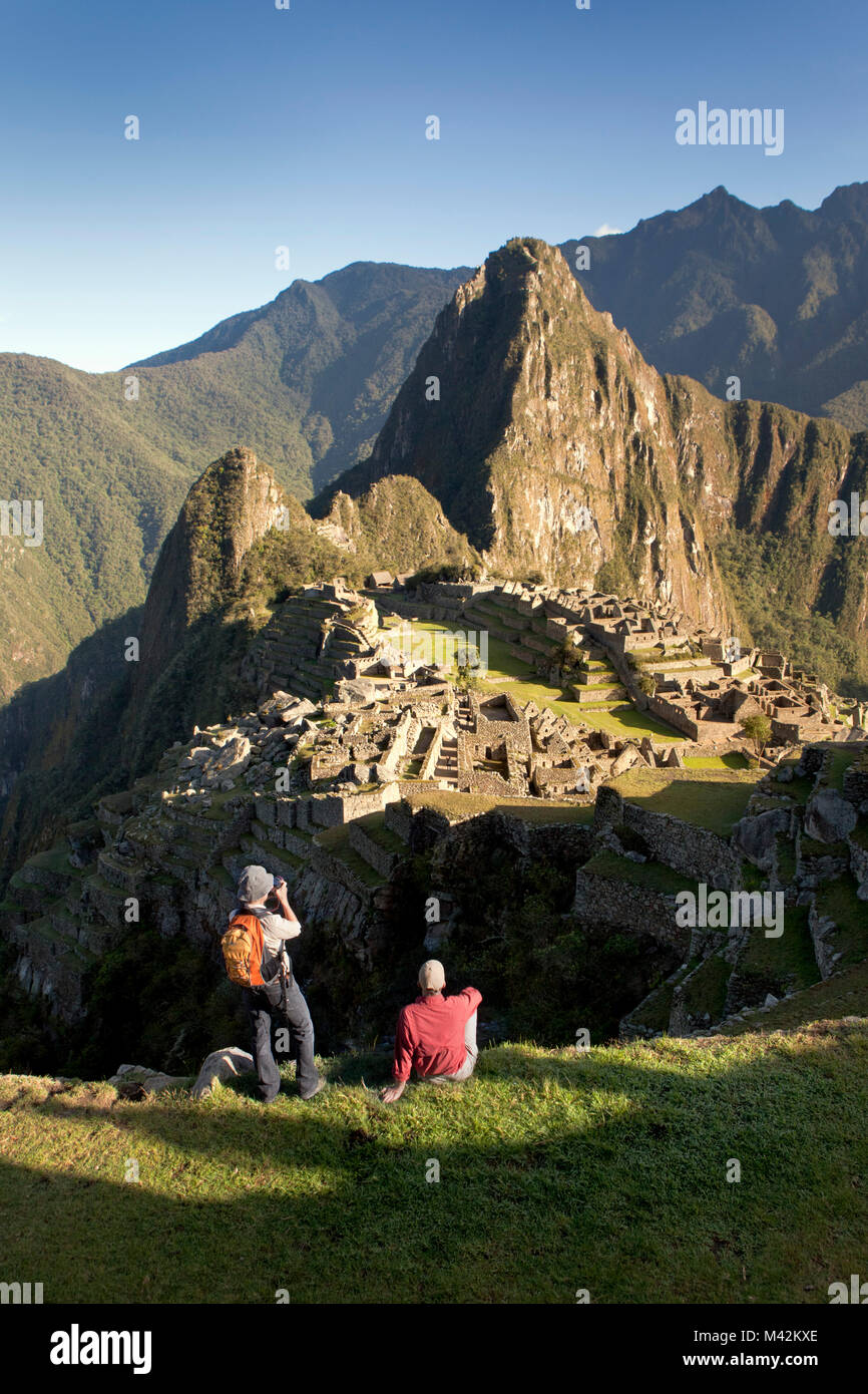 Peru, Aguas Calientes, Machu Picchu. 15th-century Inca site located at 2,430 metres. Unesco World Heritage Site. Tourists, woma  and man. Stock Photo