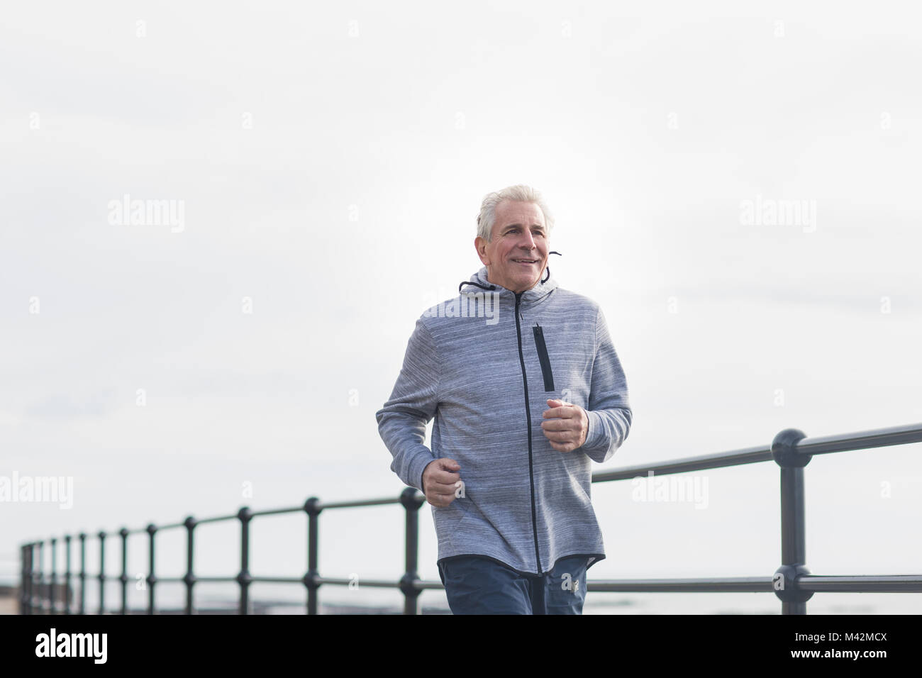 Senior man jogging outdoors Stock Photo
