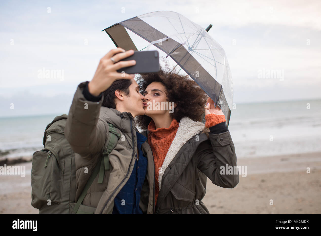 Young couple taking a selfie kissing on a winter break Stock Photo