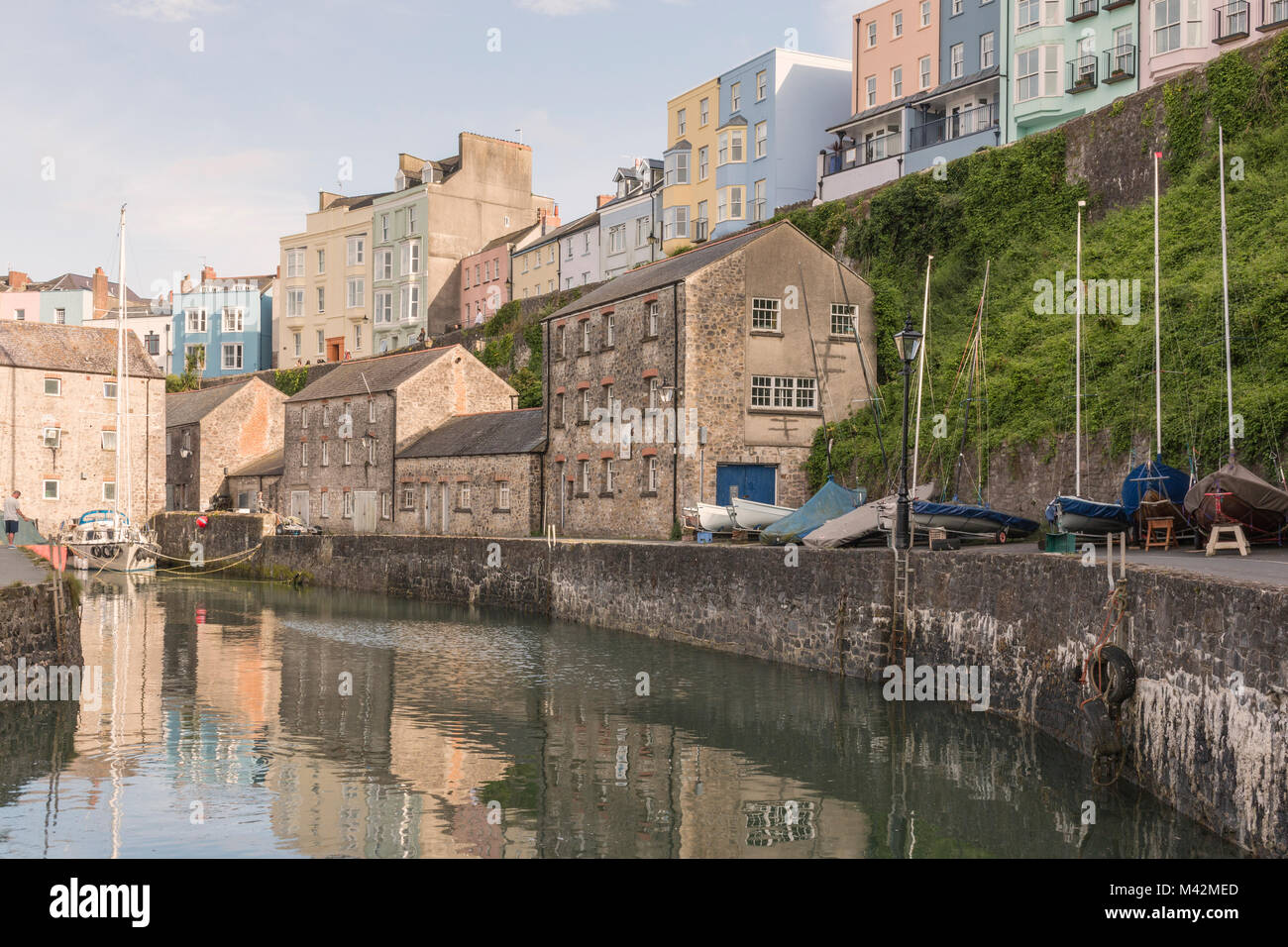 An image of Tenby quayside and the surrounding pastel-coloured houses which overlook, shot in evening light, Tenby, Pembrokeshire, South Wales. Stock Photo